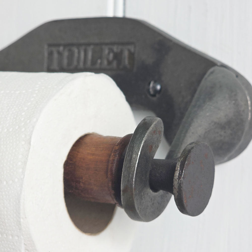 Metal toilet paper holder with wooden core on a white background