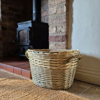 Small oval log and kindling basket next to log burning stove.