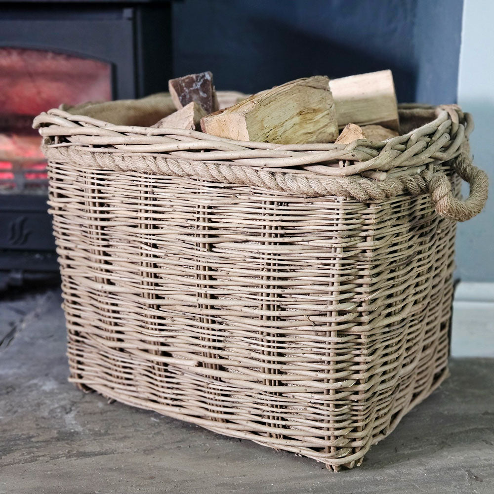 Small Mill wicker log basket filled with logs next to a lit log burner.