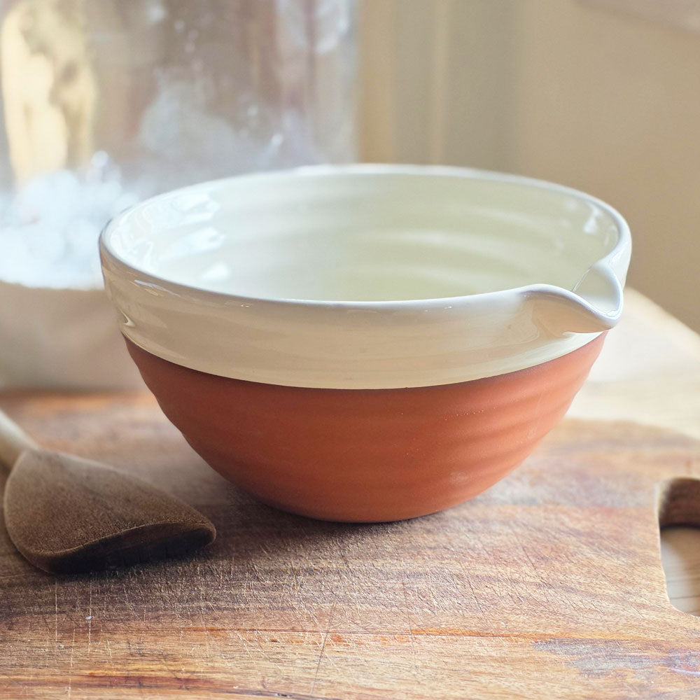 Ceramic mixing bowl on a board.