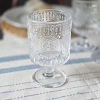 Small embossed wine glass on a blue striped tablecloth