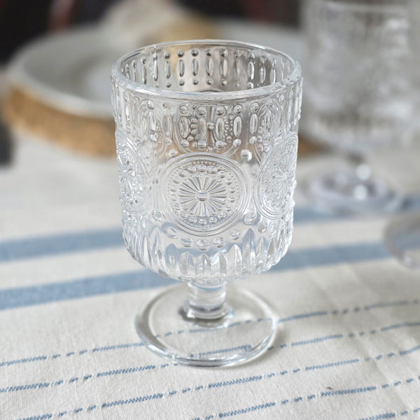 Small embossed wine glass on a blue striped tablecloth