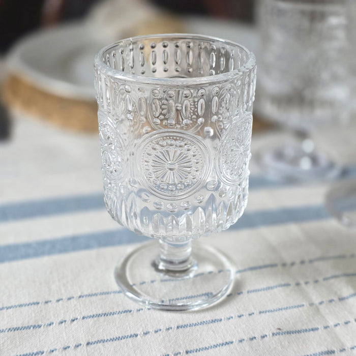 Small embossed wine glass on a blue striped tablecloth