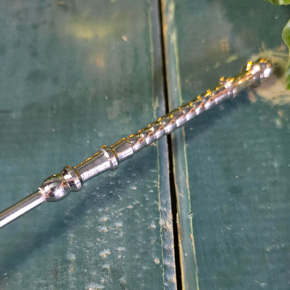 Close up of silver coloured metal candle snuffer.