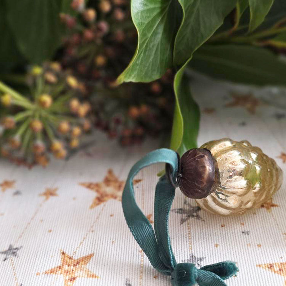 Gold glass Christmas decoration and foliage on stars wipe clean tablecloth