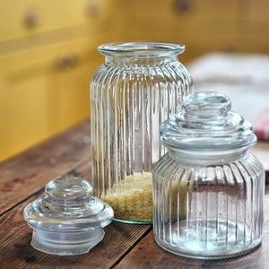 Glass storage jar containg rice with lid removed alongside a smaller glass storage jar