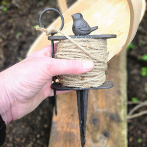 Holding a cast iron garden line marker.