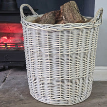 White Provence lined log basket filled with logs next to a lit wood burning stove