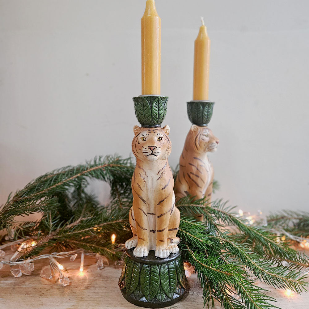 Tiger candle holder next to Christmas lights and foliage