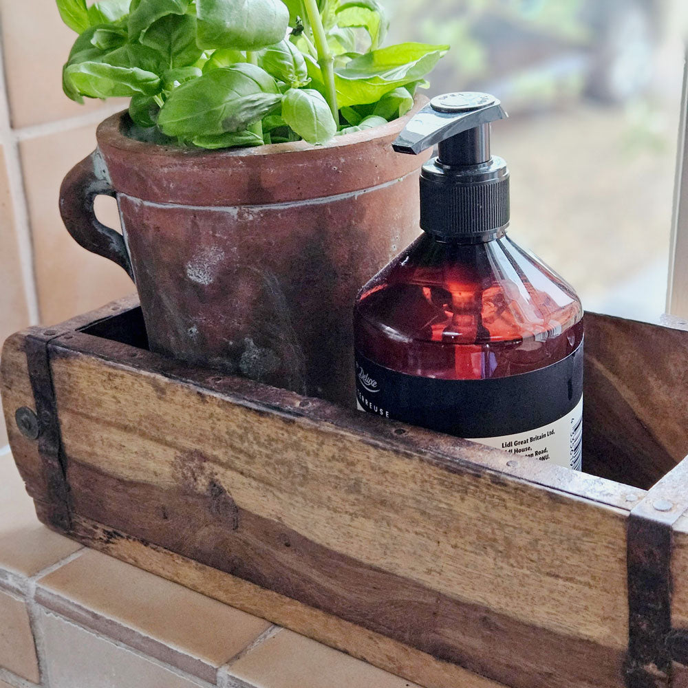 Vintage brick mould used as a kitchen windowsill caddy.
