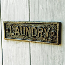 Cast metal laundry room door plate sign